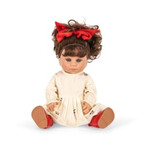 lalka z czerwoną kokardą na głowie w czerwonych butach w białej sukience z wisienkami