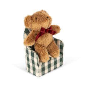 jasnobrązowy miś z czerwoną kokardką z fotelem w kratkę